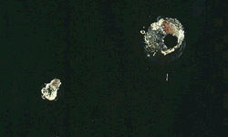 Photograph of holes in acrylic, 2nd larger hole is from reflected beam.